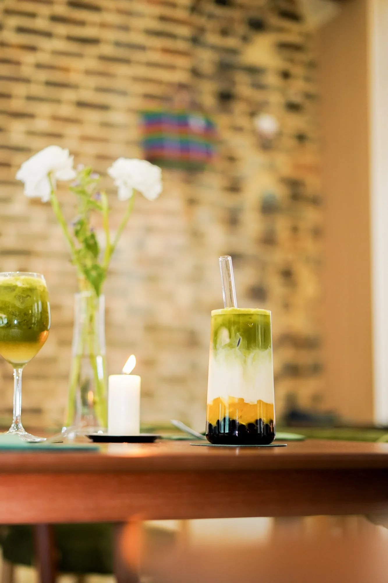 deux verres matcha cote a cote table bougie fleurs