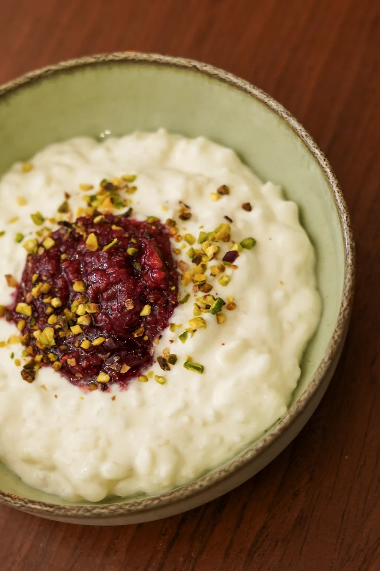 Riz au lait framboise pistaches portrait haut, bol vert sauge