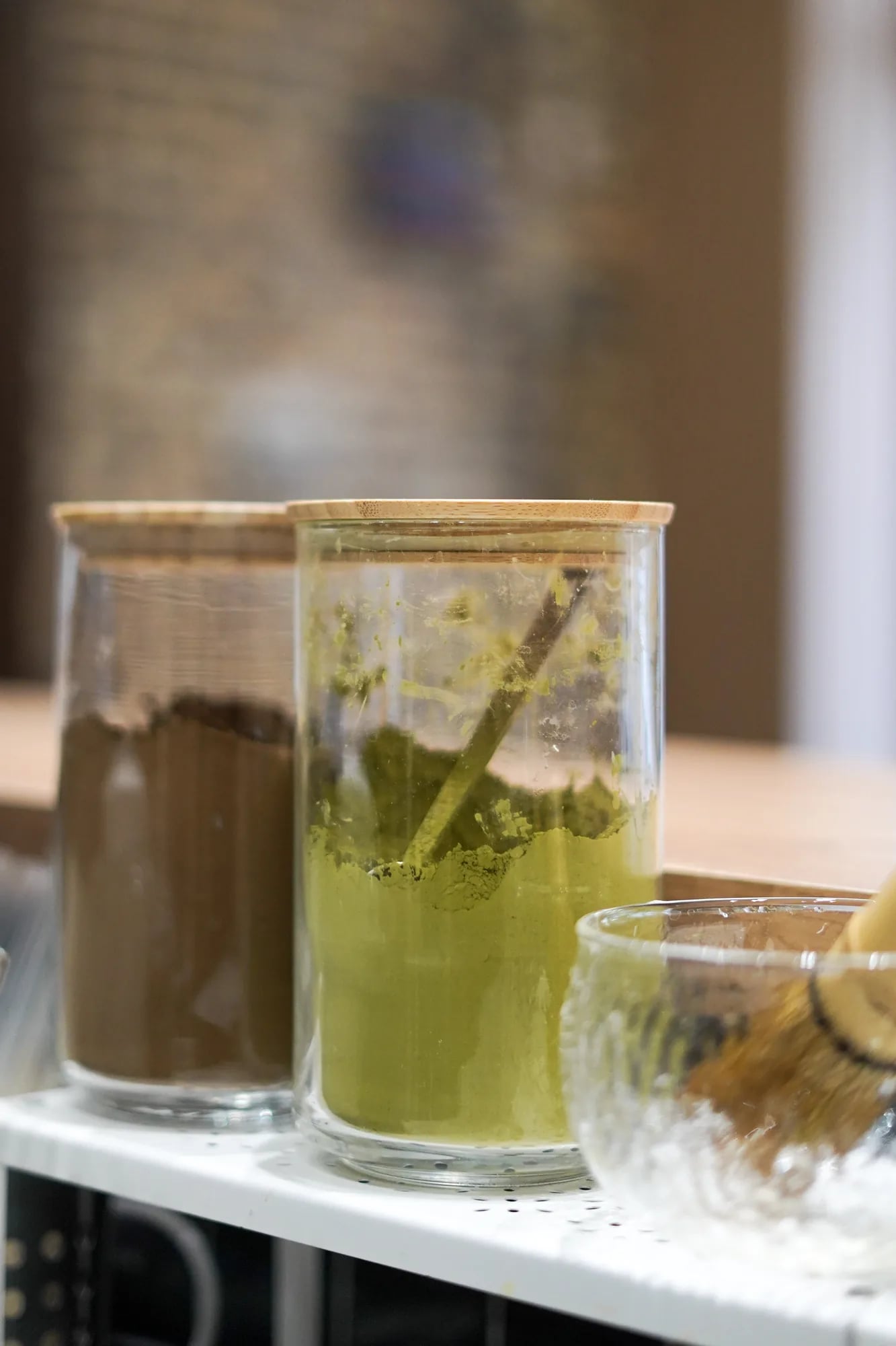Bocaux verre avec poudre matcha verte et poudre brown sugar marron, fouet bambou