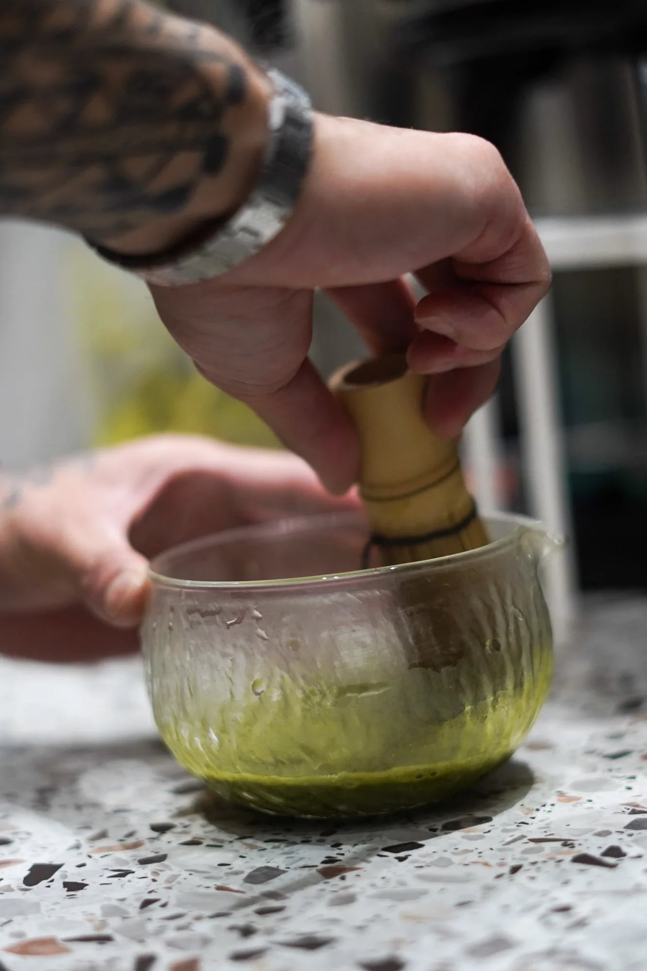 mains fouettent matcha bol verre tatouage bras
