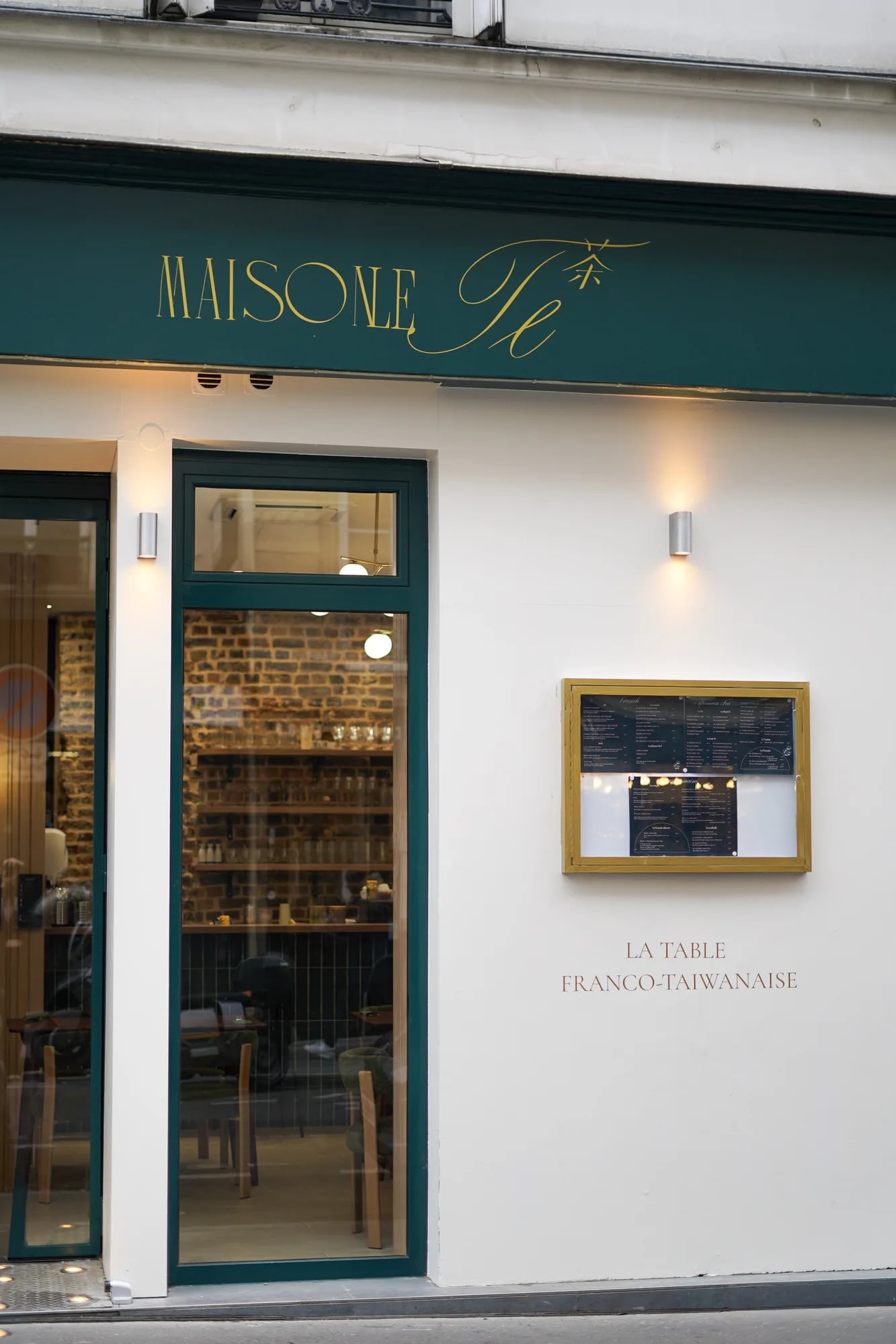 Façade complète avec porte d'entrée verte, vitrine et menu encadré doré